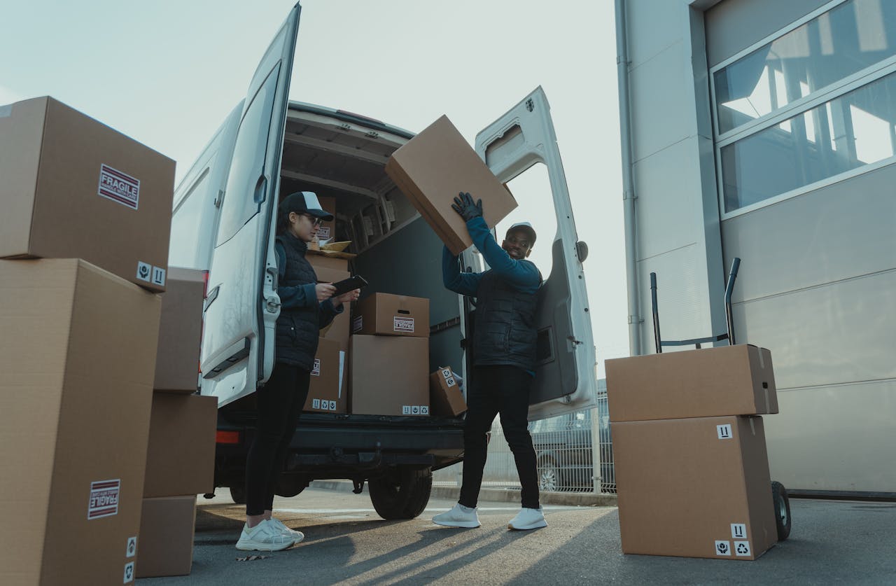 Mastering the First Impression: Your intriguing post title goes here Workers loading boxes into a delivery van at a warehouse facility outdoors.